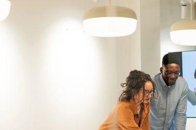 Two colleagues collaborate over a project in a modern office space.