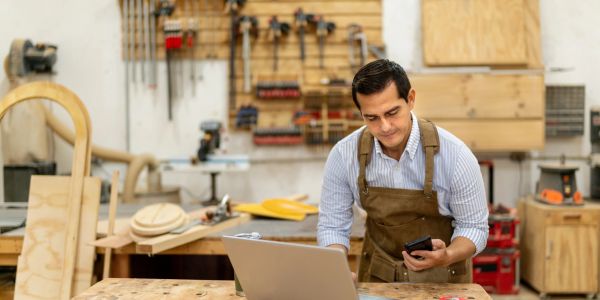 Carpenter working with a laptop in the workshop.