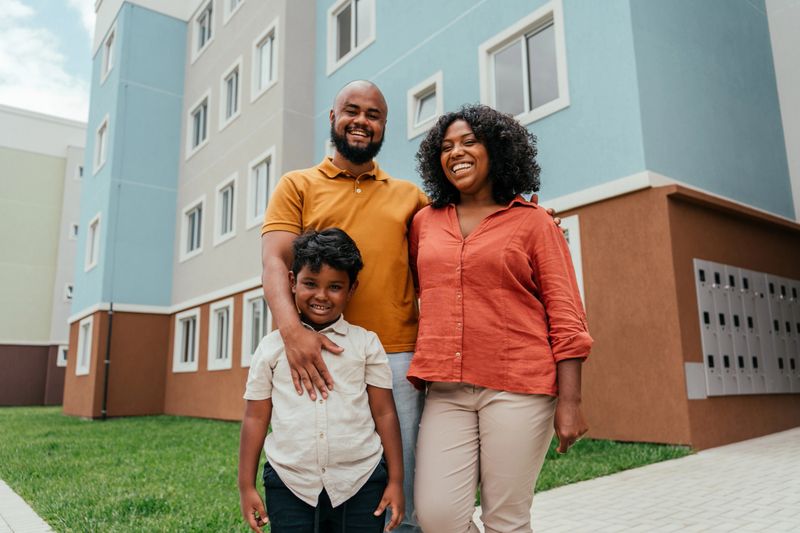 Portrait of a happy family in front of their new apartment