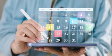 Person interacts with a digital calendar on a tablet.