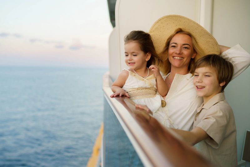 Carefree mother and her two children looking at sea from a cruise ship