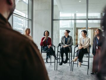 A diverse group of professionals engaged in a discussion in a modern office.