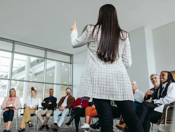 Woman leading a meeting or workshop with engaged participants.