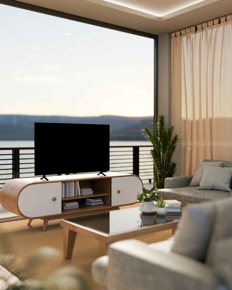 A contemporary living room with a stunning view through a large window features a TV on a sleek TV cabinet, a comfortable sofa, and modern home decor. 3d render, 3d illustration