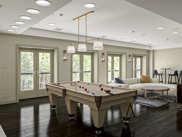 Modern game room with a pool table and seating area.