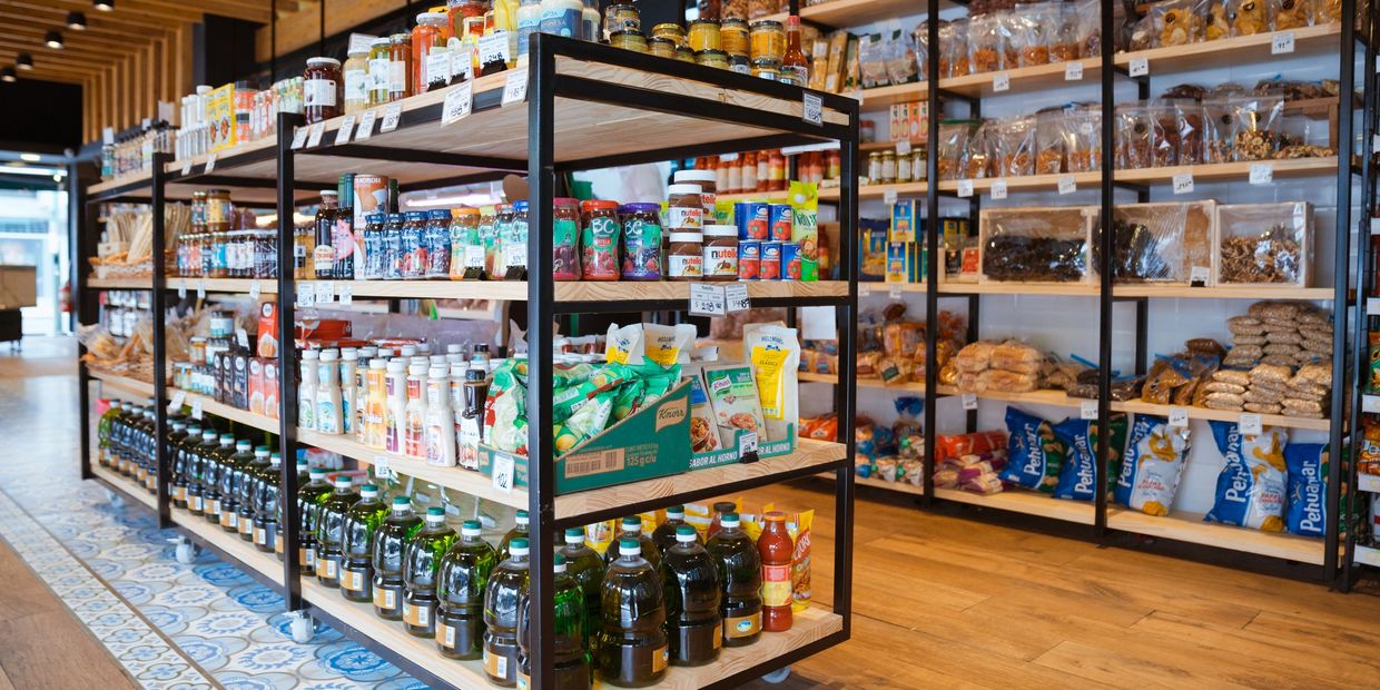 Grocery store aisle with shelves stocked with various food products.