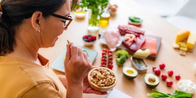 Woman enjoying a healthy snack of nuts.