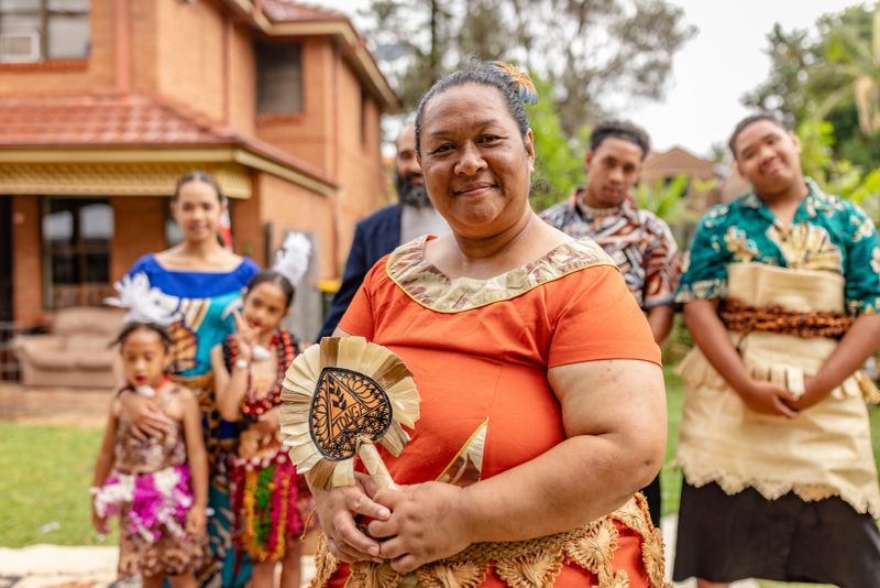 A Tongan family participates in daily activities in Sydney, Australia, highlighting their rich culture and traditions. The scene reflects joy and togetherness among family members.