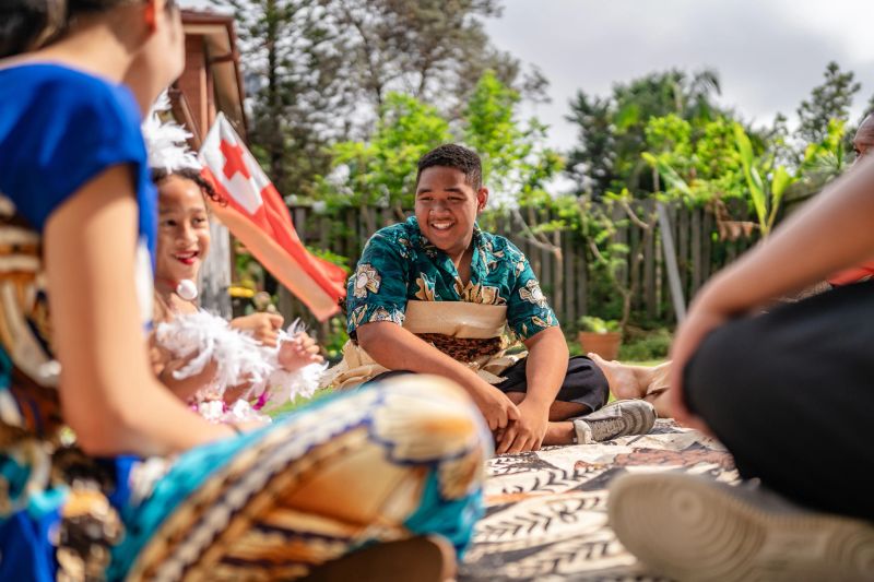 In the vibrant atmosphere of Sydney, a Tongan family enjoys their daily life, embracing cultural traditions and sharing joyful moments together, reflecting their rich heritage.