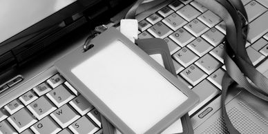Two identification badges on a laptop keyboard.