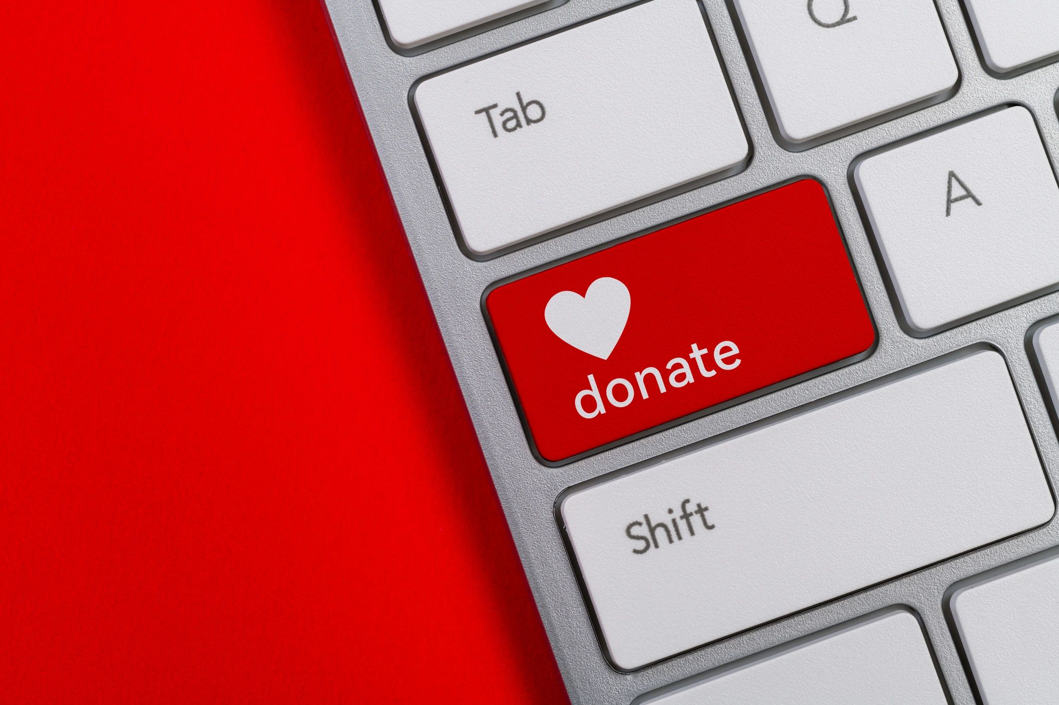 Close-up of a donate key on a keyboard with a heart symbol.