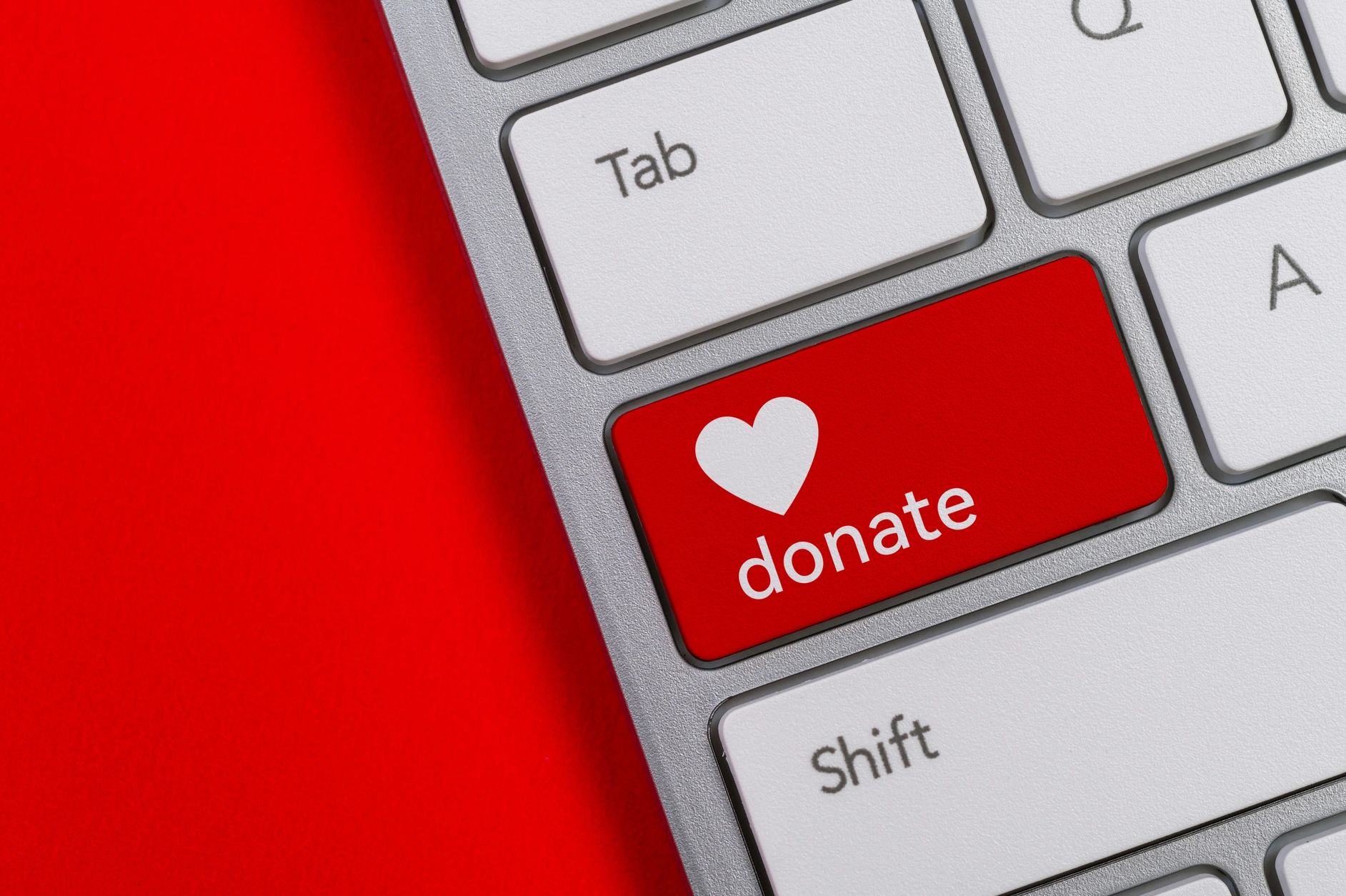 Red donate key on keyboard with a heart symbol.