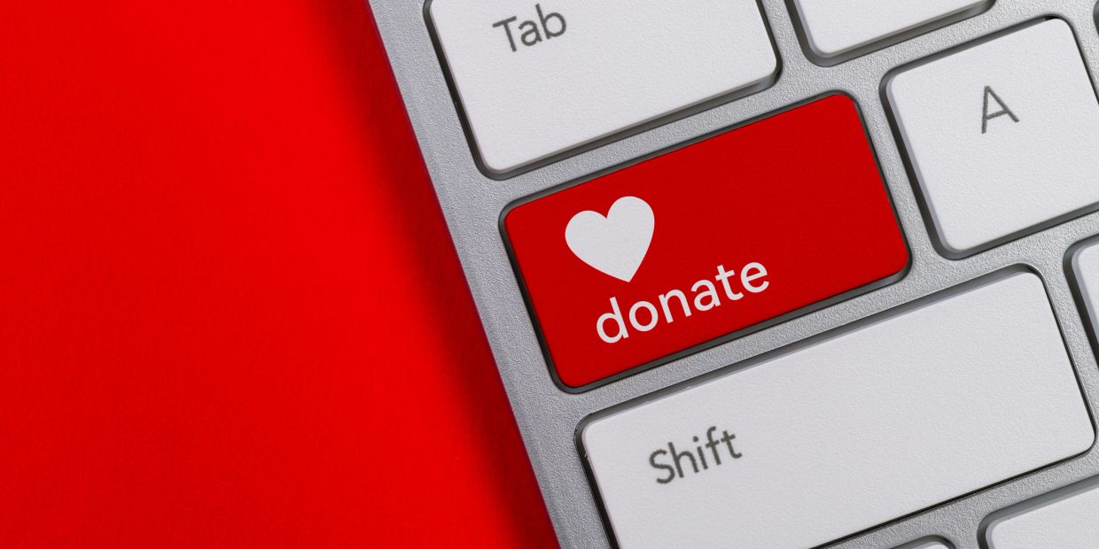 Keyboard key with a red donate button and heart symbol.