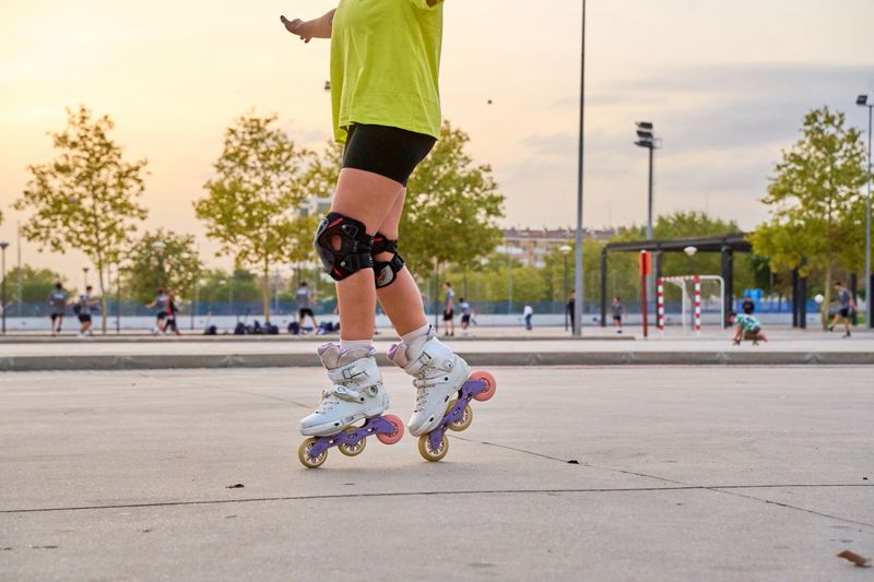 Man practicing roller skating tricks in park at sunset