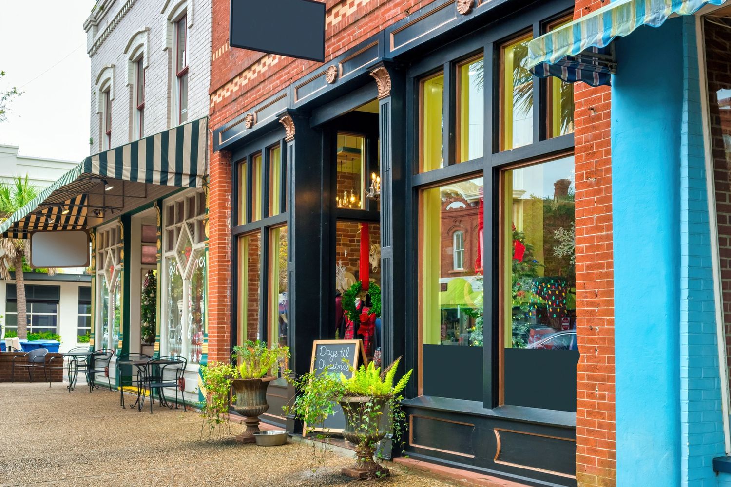 Colorful storefronts with festive decorations on a quiet street.
