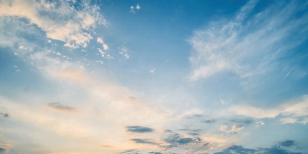A sky with scattered clouds during sunset.