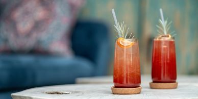 Two refreshing cocktails on a table with a blurred background.