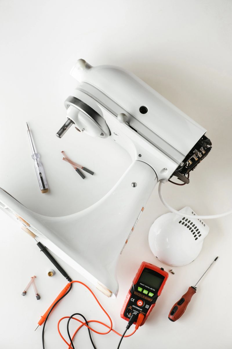 Disassembled broken standing kitchen aid mixer on the white background. Repair and service of stand kitchen food processor advertising template with a free space for text.