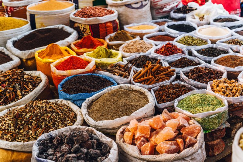 A vibrant selection of spices and herbs displayed in sacks at a bustling market in Old Delhi, showcasing a rich culinary heritage and vivid colors.