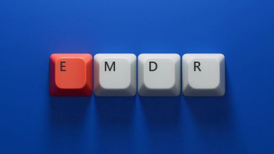 Keyboard keys spelling EMDR on blue background.
