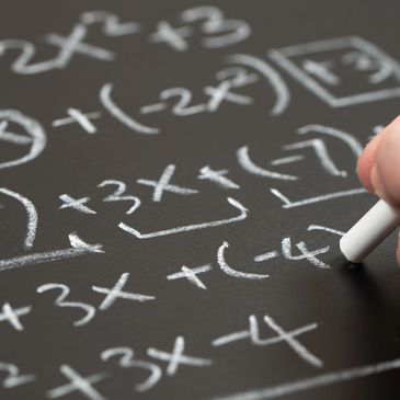 A close-up of algebra equations being solved on a chalkboard