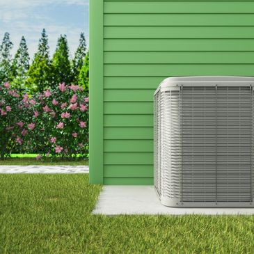 Outdoor air conditioning unit next to a green house with flowers and trees in the background.