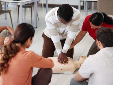 Man preforming cpr in group