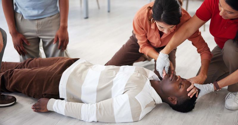 People, demonstration and class for first aid, life saving and learning for healthcare in office and instructor. Teaching, safety and training of employees for CPR, teacher and technique for group