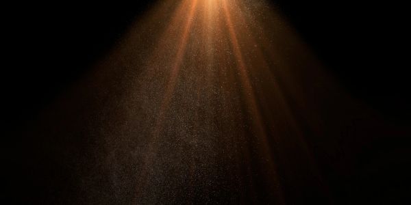 Warm light beams shining through a dark space.
