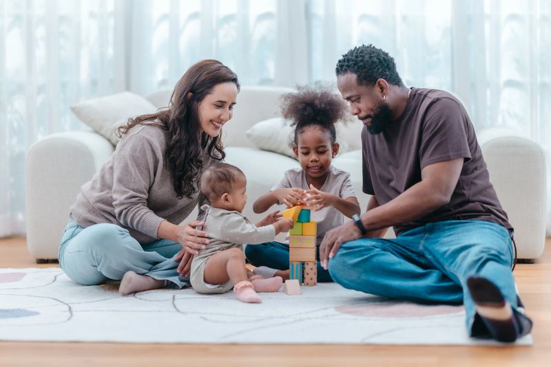 Heartwarming scene of diverse family spending quality time together in living room. The group includes parents and two children, showcasing love, connection, togetherness in modern family setting