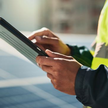 Person in safety vest using a tablet.