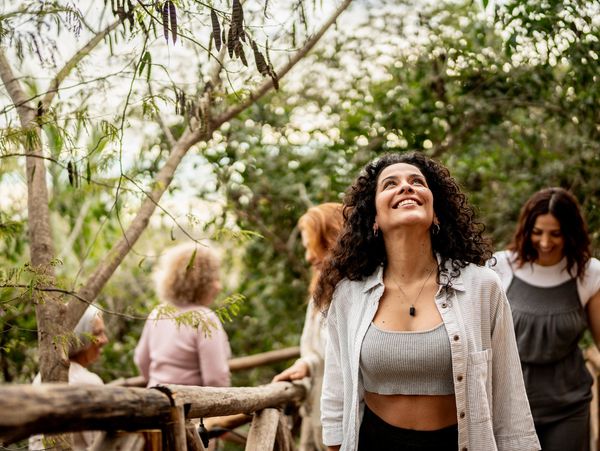 Woman smiling and looking up outdoors.
