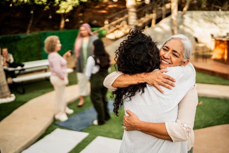 Senior woman embracing friend outdoors