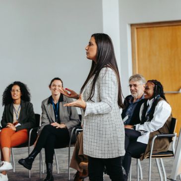 Woman leading a training session for seated staff — Professional Development service card describing