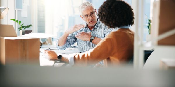 Two colleagues discussing work in an office.