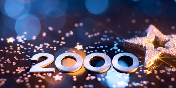 Metallic numbers forming 2000 with a glittering star on a dark, bokeh background.