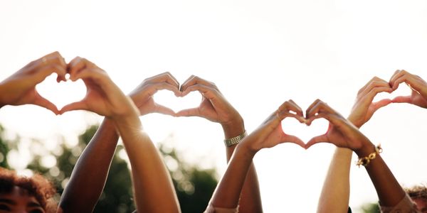 Hands forming heart shapes in the sunlight.