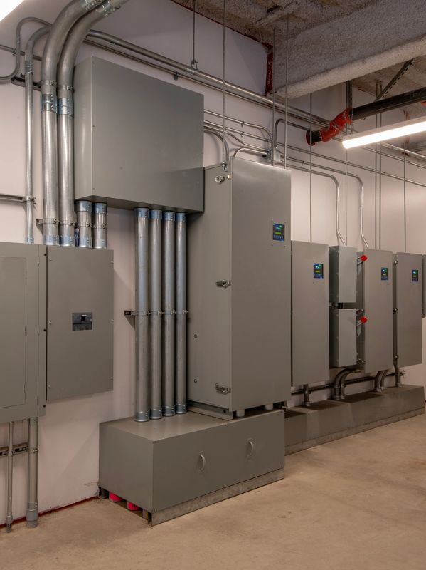 sangster hybrid solar energy system complete solar energy solutions with Industrial electrical panels and conduits in a utility room application.