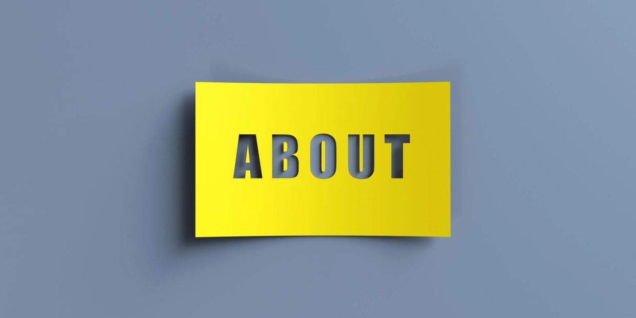 Yellow paper with the word ABOUT cut out.