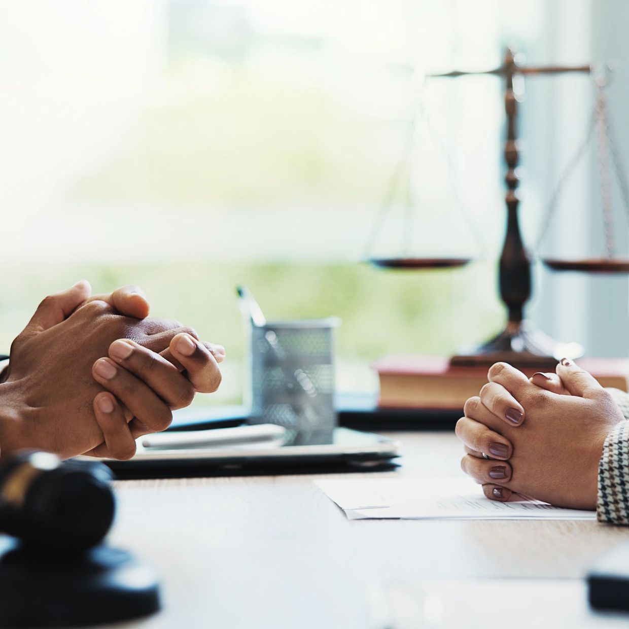 Two people in a legal consultation with hands clasped.