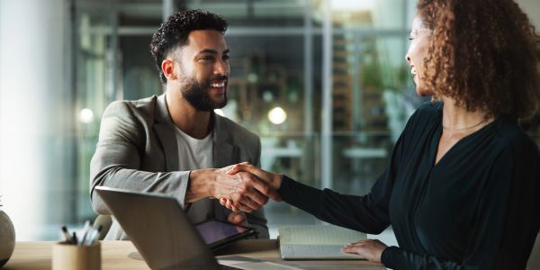 Group of people smiling and making a business agreement.