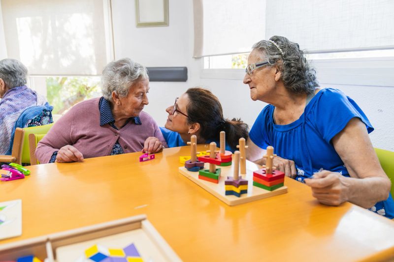 Senior adults engaging in interactive games with a caregiver in a nursing home, enhancing communication and mental stimulation