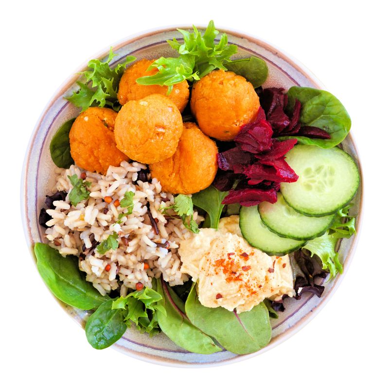 Healthy homemade salad bowl with falafels, hummus, quinoa and vegetables. Top view isolated on a white background.