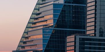 Modern glass skyscrapers reflecting the sunset.