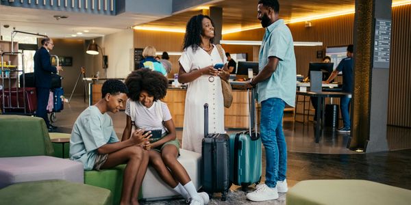 A family with luggage waiting at a hotel lobby.