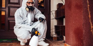 Person in protective gear fumigating an area.