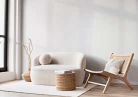 Minimalist living room with a curved sofa and wooden chair.