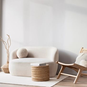 Minimalist living room with neutral tones and cozy furniture.