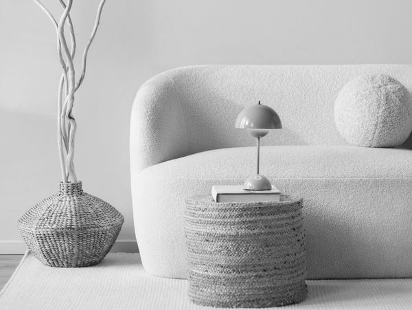 Cozy minimalist living room with a white curved sofa and natural woven accents.