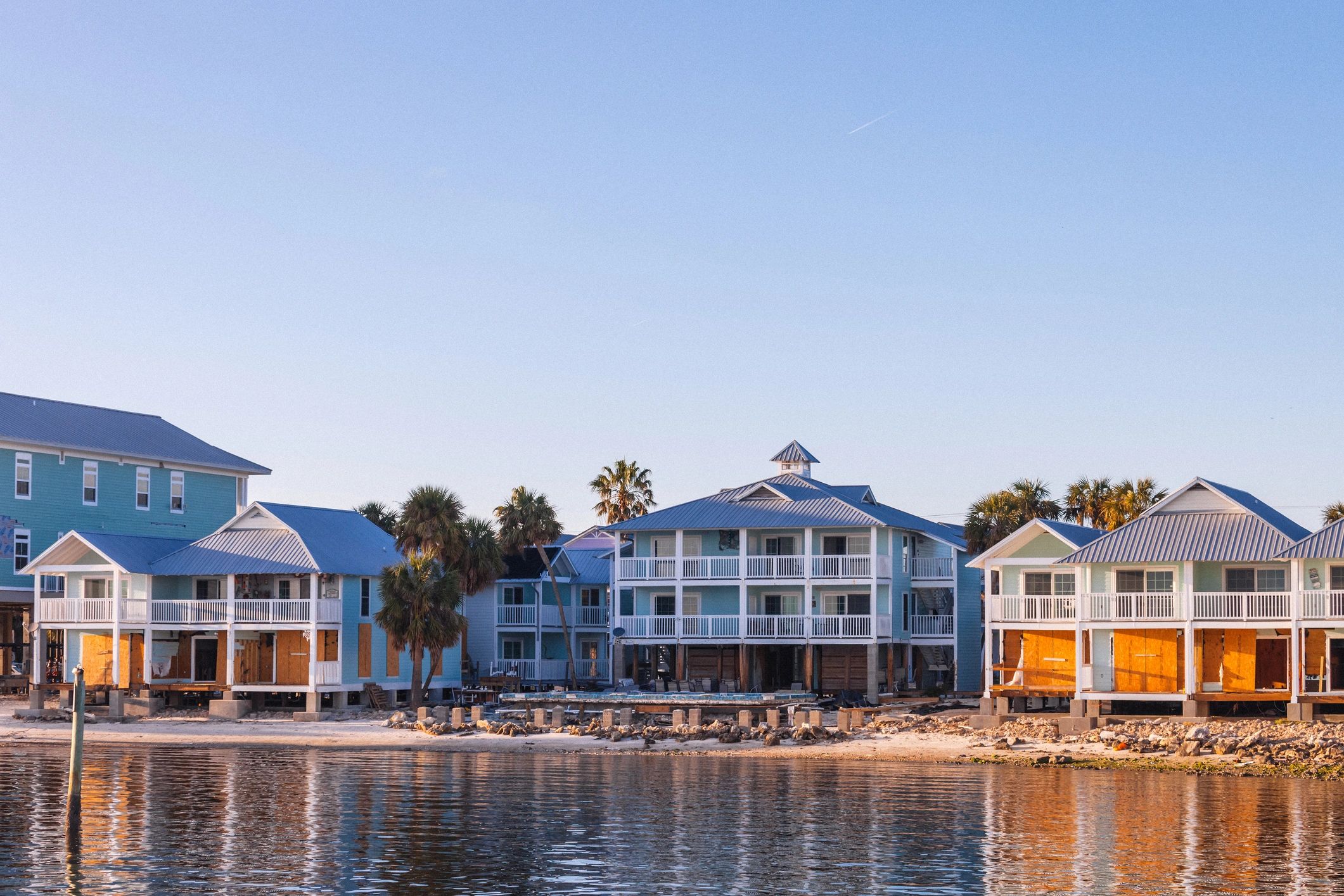 Beach houses by the water during sunset.